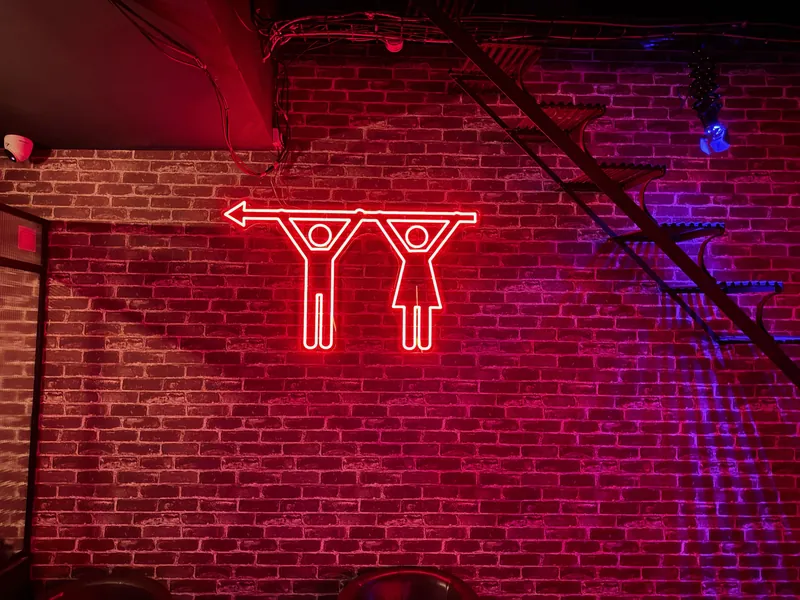 Néon rouge sur mur de briques dans le Maya Klub